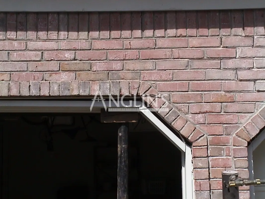 crack in a brick wall over a garage door