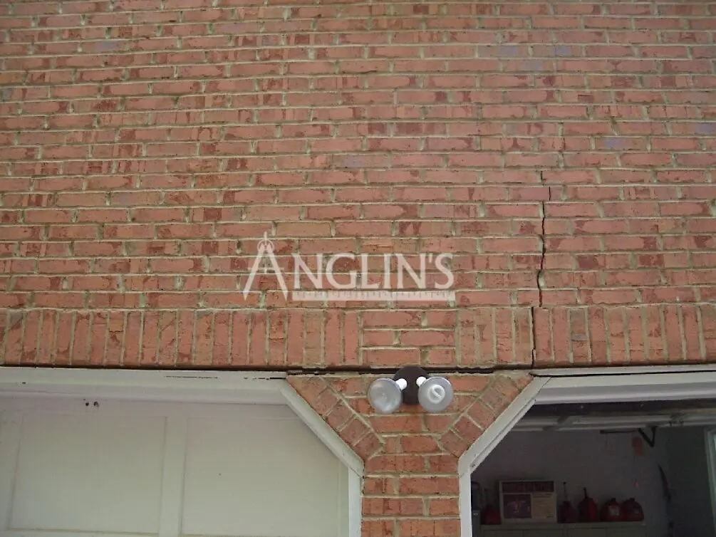 crack in a brick wall over the garage door